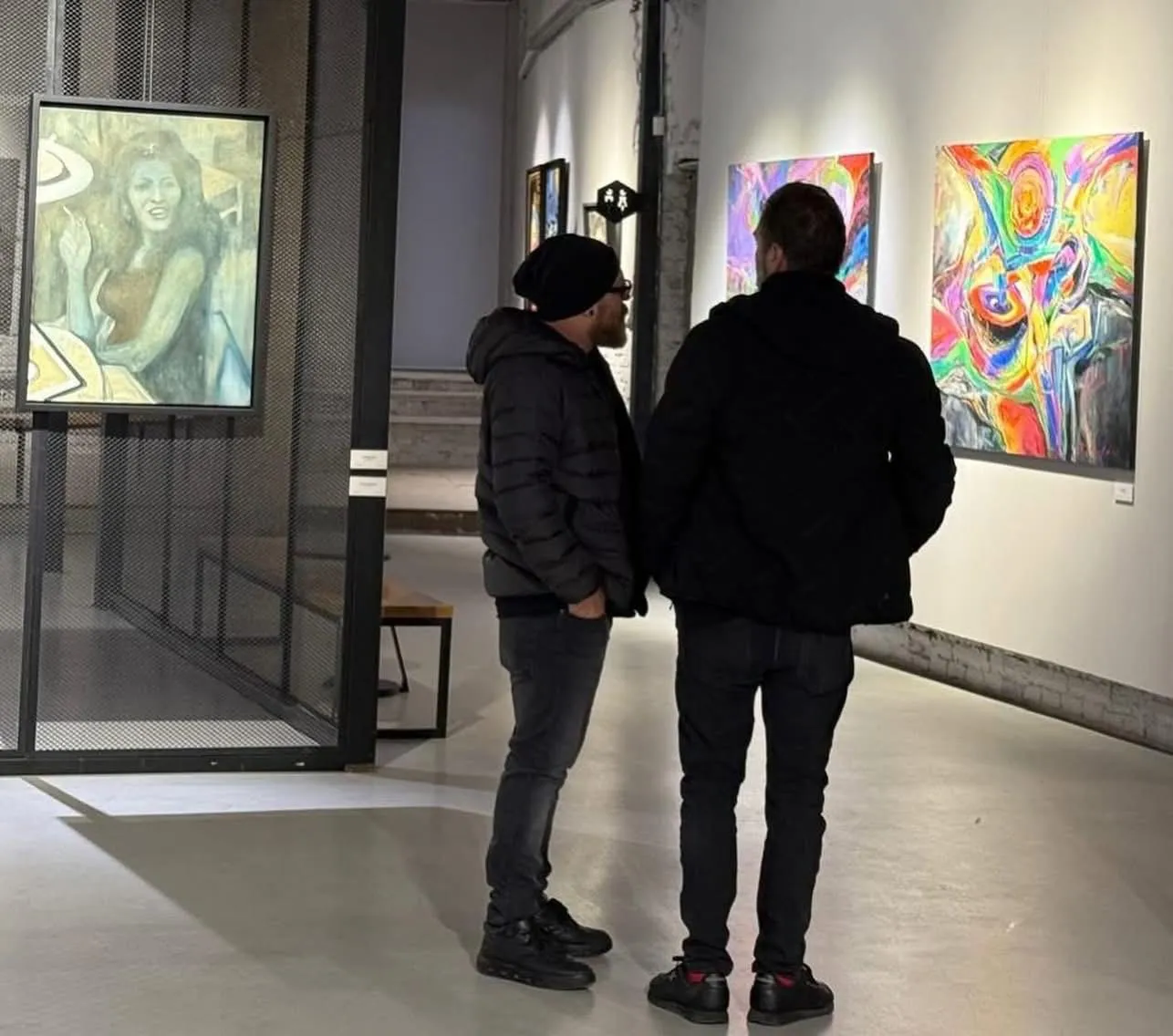 Boti and a friend in the gallery at the opening, looking at paintings