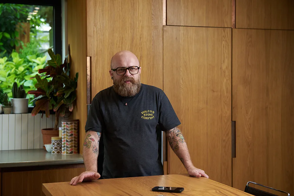 Botond Ferenczy at the oak and copper kitchen island he designed for his own home