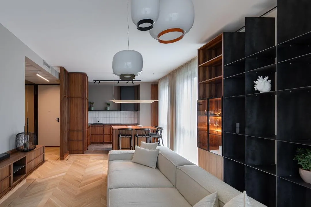Finished living space with walnut joinery and a black steel shelf wall