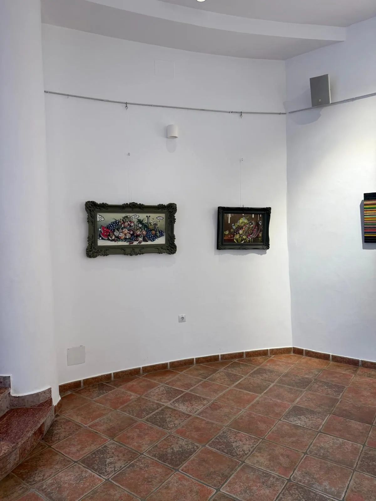 Two framed still lifes in a white corner of the gallery