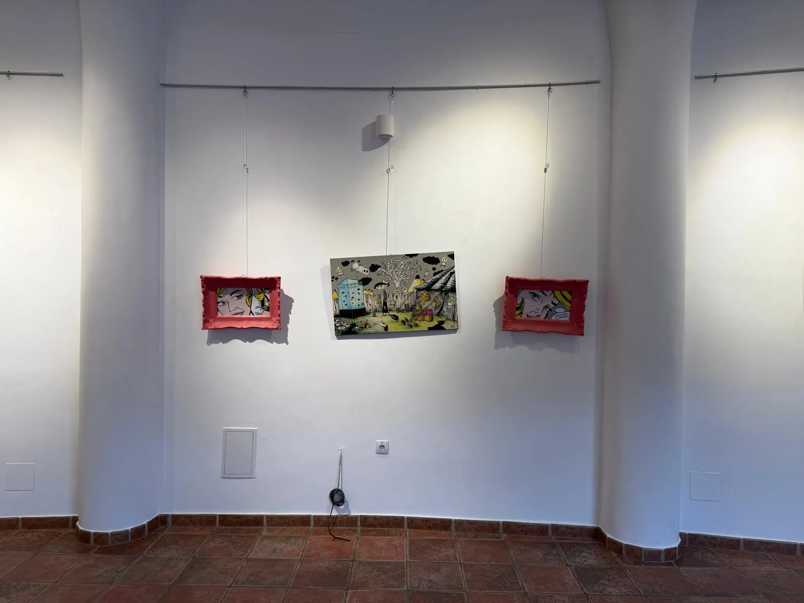 A white vaulted room with two pink-framed pop panels and a garden canvas hung from a rail